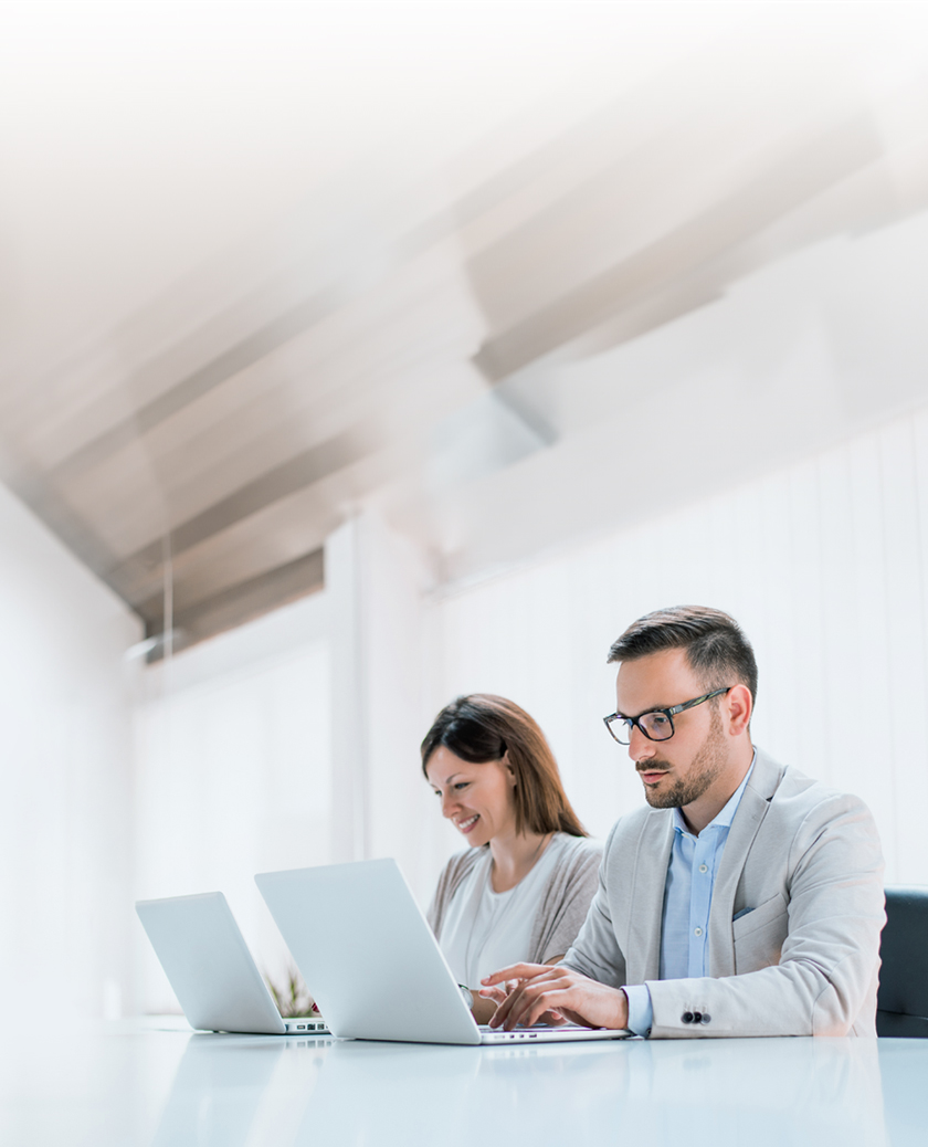 Two administrators are managing devices using LG SuperSign Control+ on personal PCs.