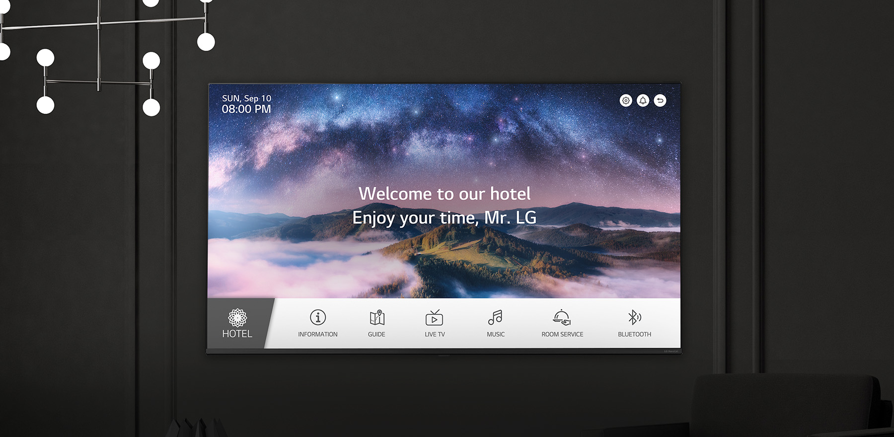 A wall in a dimly lit room features an LG TV, displaying a welcome message using the LG Pro:Centric Direct solution.